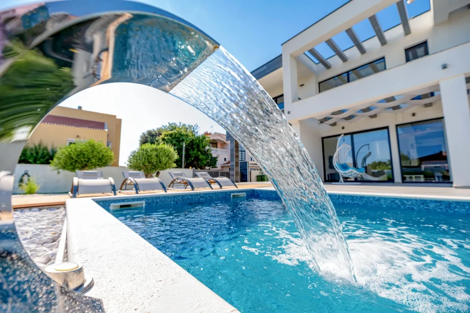 Heated swimming pool with fountain in front of private Villa Ares in Zaton
