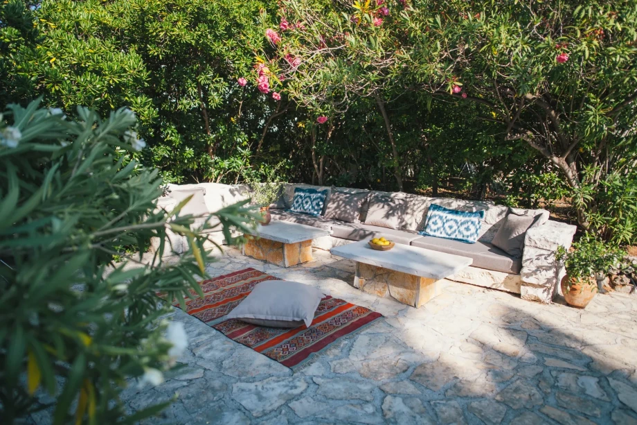 An inviting sitting area with a cozy couch, a stylish rug, and a table for drinks or snacks is highlight of Villa Bol Retreat.