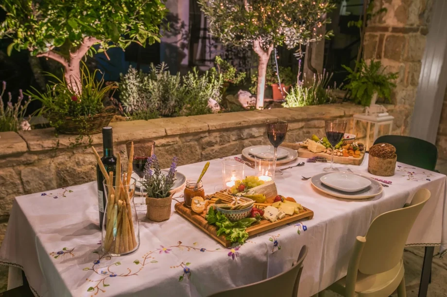 A dinner table at Villa Sweet Home in Split Old Town, elegantly set with candles and flowers for a cozy dining experience.