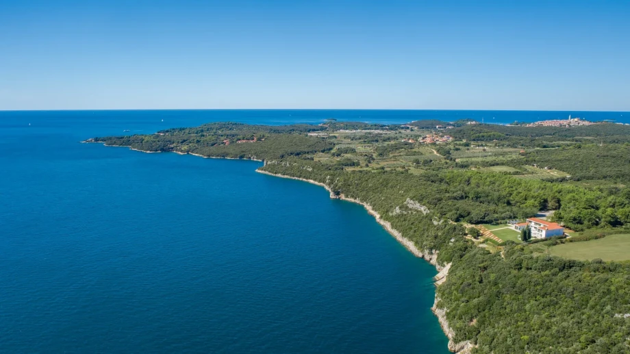 Aerial view of the coast and lush green forest surrounding the luxury private villa Ultima in Istria.
