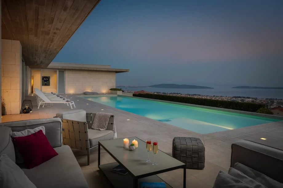 Evening view of private heated pool, terrace, and outside seating area in Luxury Villa Floora with sea view near Split