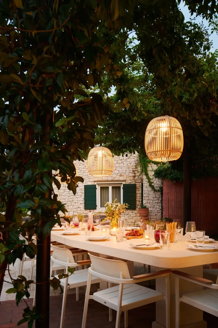 A dining table surrounded by white chairs in the beautiful Villa Priska, highlighting a chic interior design.