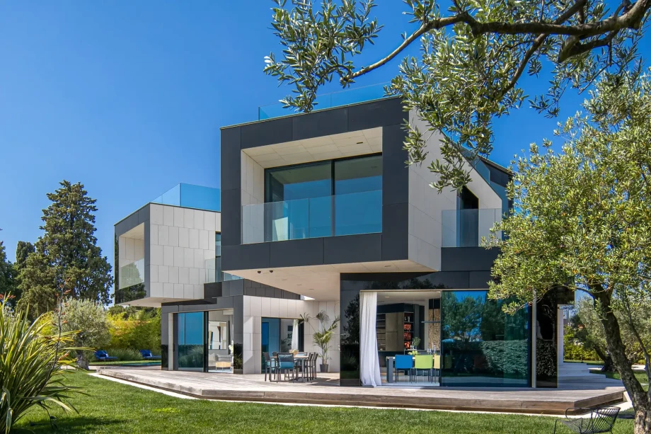 The front of the villa includes open entrances to the kitchen and downstairs, along with an outdoor table and chairs