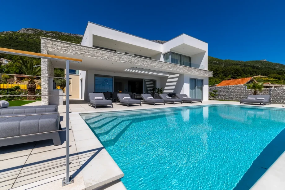 Modern Villa Nikita in Croatia featuring a sleek design and a big swimming pool surrounded by loungers.