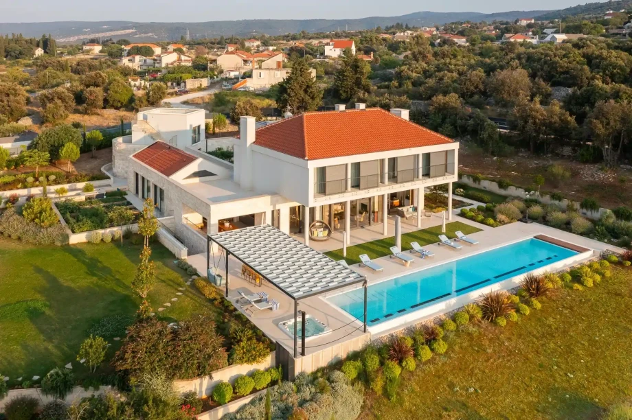 Aerial perspective of a luxury villa nestled in the countryside of island Brac, highlighting its sophisticated design and natural surroundings.