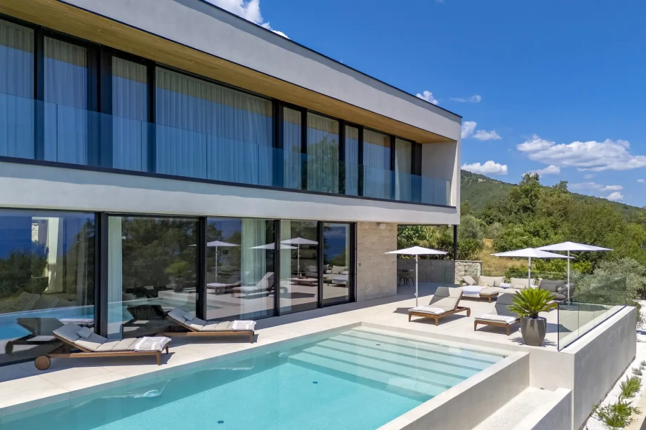 Modern villa Mistique with a pool and lounge chairs, perfect for relaxing in the sun during your stay in Croatia's finest holidays.