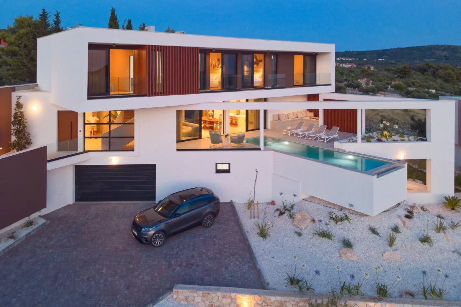 Modern Villa Serena in Primosten features a stunning pool and a spacious parking lot in front.